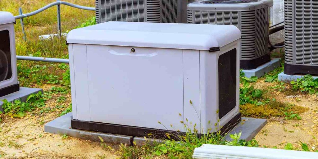 Outdoor standby generator installed on a concrete pad near HVAC units
