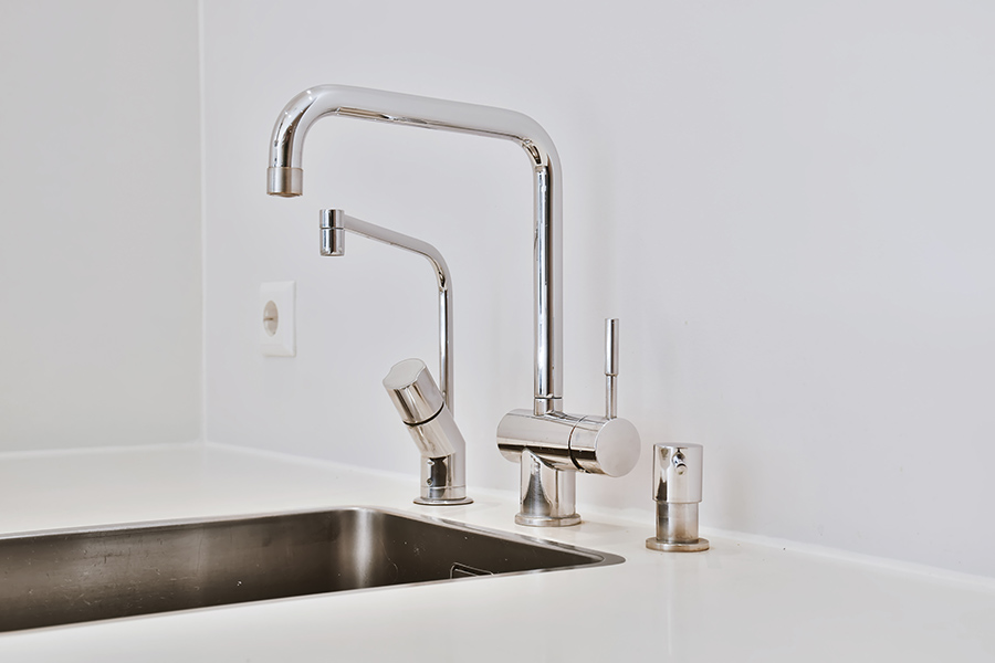 Modern kitchen sink with a sleek chrome faucet and accessories
