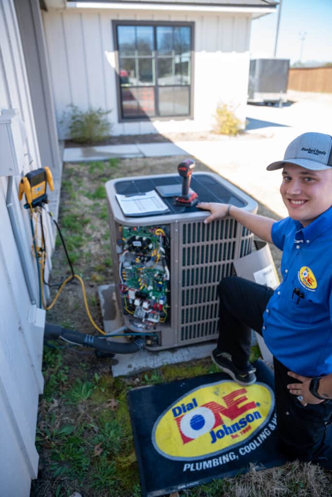 HVAC Technician working on an outdoor compressor.